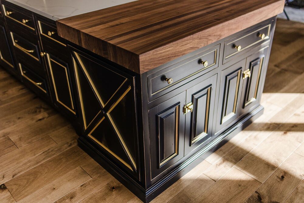 Rich walnut butcher-block, paired with black rubbed through cabinet finish, and accented with a gold glaze is what gives this kitchen a sense of glamour and sophistication.